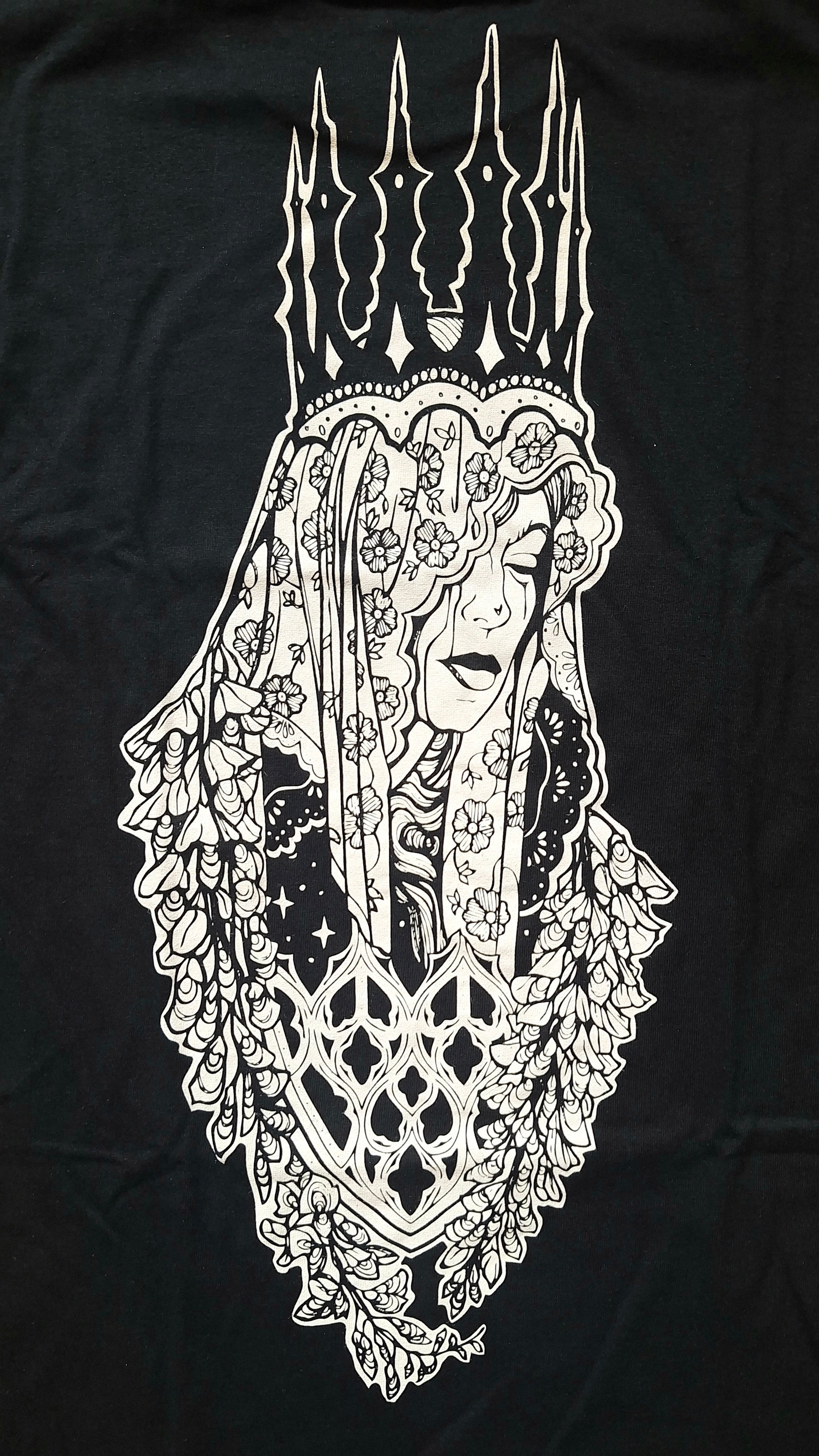 A black t-shirt featuring a large white graphic print of a crowned woman in a floral veil and crown